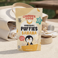 Wunderbaby Puffies Banana package on a wooden surface on a mat in a park